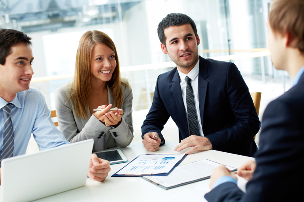 Image of two business women seated at a table having a discussion